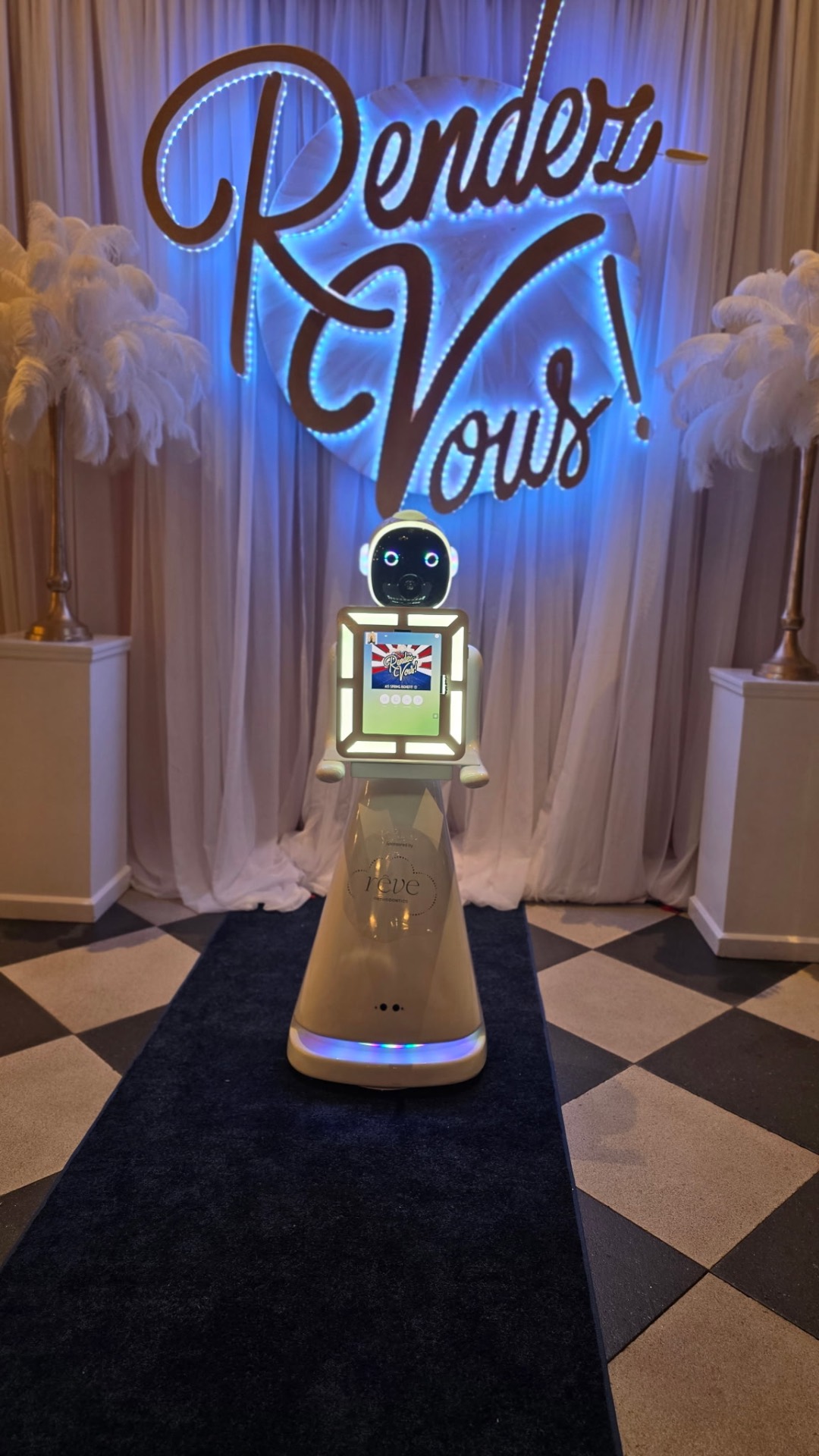 Rendez-Vous LED marquee sign with roaming photo booth robot on checkered runner